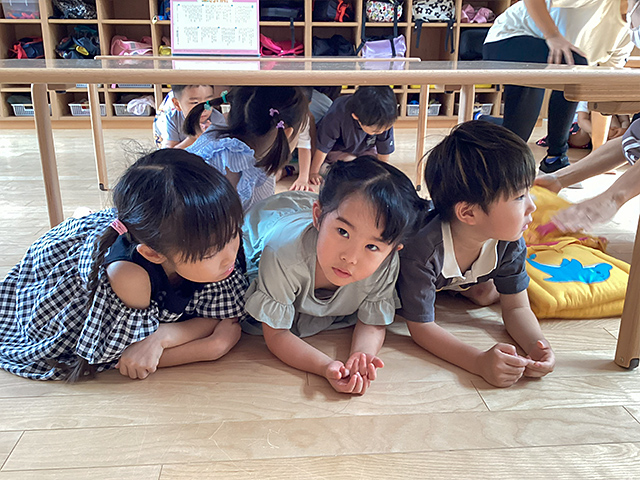 机の下でダンゴムシポーズ